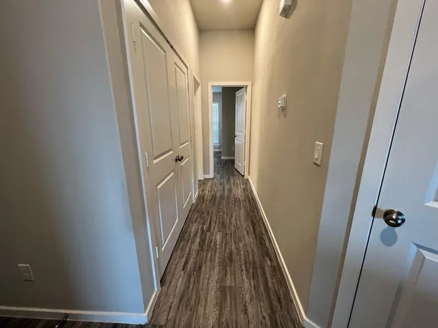 a view of a hallway with wooden floor and staircase