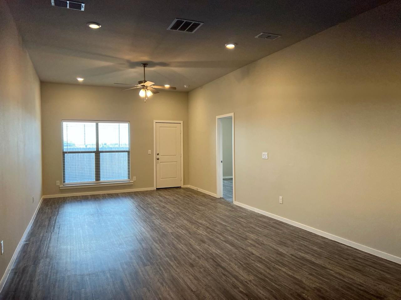 2125 North Texas Avenue, Unit B Lubbock, TX 79403 - Photo 21 of 21 an empty room with wooden floor and a ceiling fan