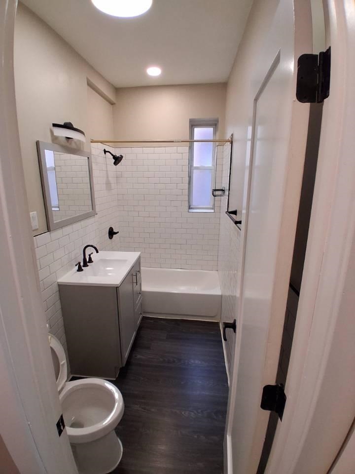 18 Reed Street, Unit 13 Jersey City, NJ 07304 - Photo 3 of 6 a bathroom with a bathtub shower sink vanity and toilet