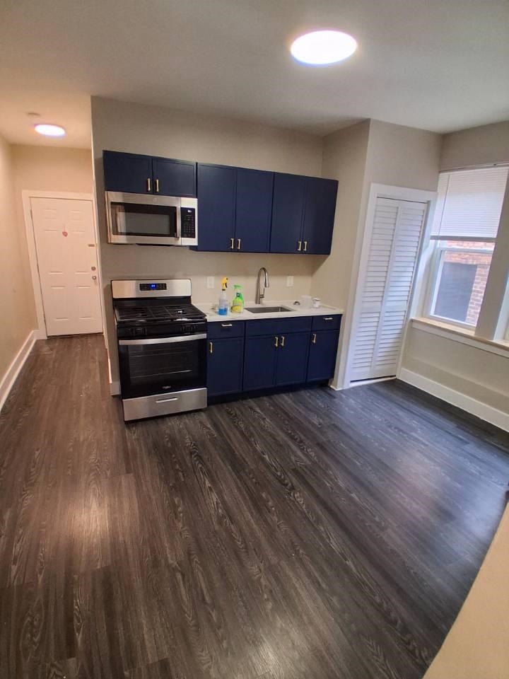 18 Reed Street, Unit 13 Jersey City, NJ 07304 - Photo 4 of 6 a kitchen with stainless steel appliances granite countertop a stove a refrigerator and a cabinets with wooden floor