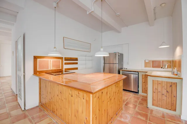 a kitchen with stainless steel appliances granite countertop a sink and a refrigerator
