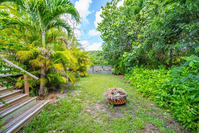 a view of an empty room with window and chandelier fan