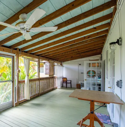 a view of a porch with furniture and floor to ceiling window