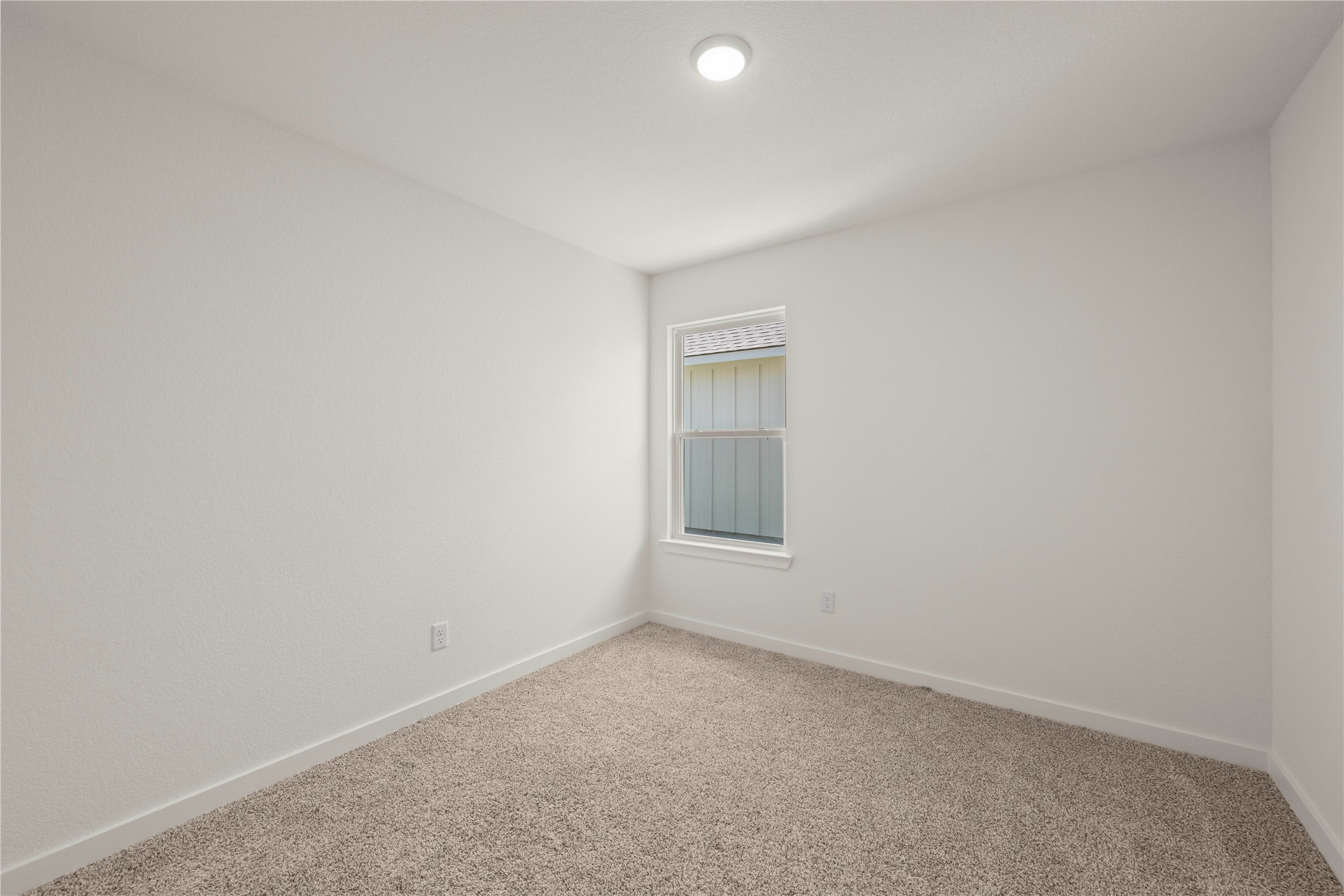 228 Gus Loop Georgetown, TX 78626 - Photo 5 of 19 A well-lit bedroom features plush carpeting and a modern window, perfect for quiet repose.