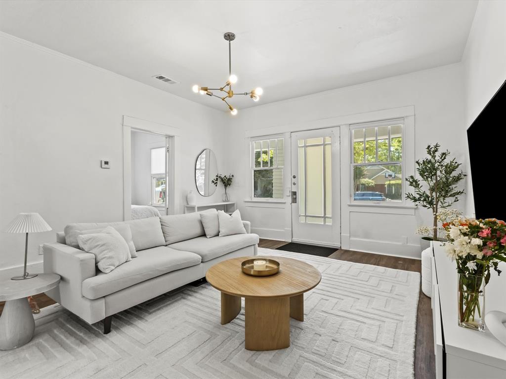 a living room with furniture a chandelier and a flat screen tv