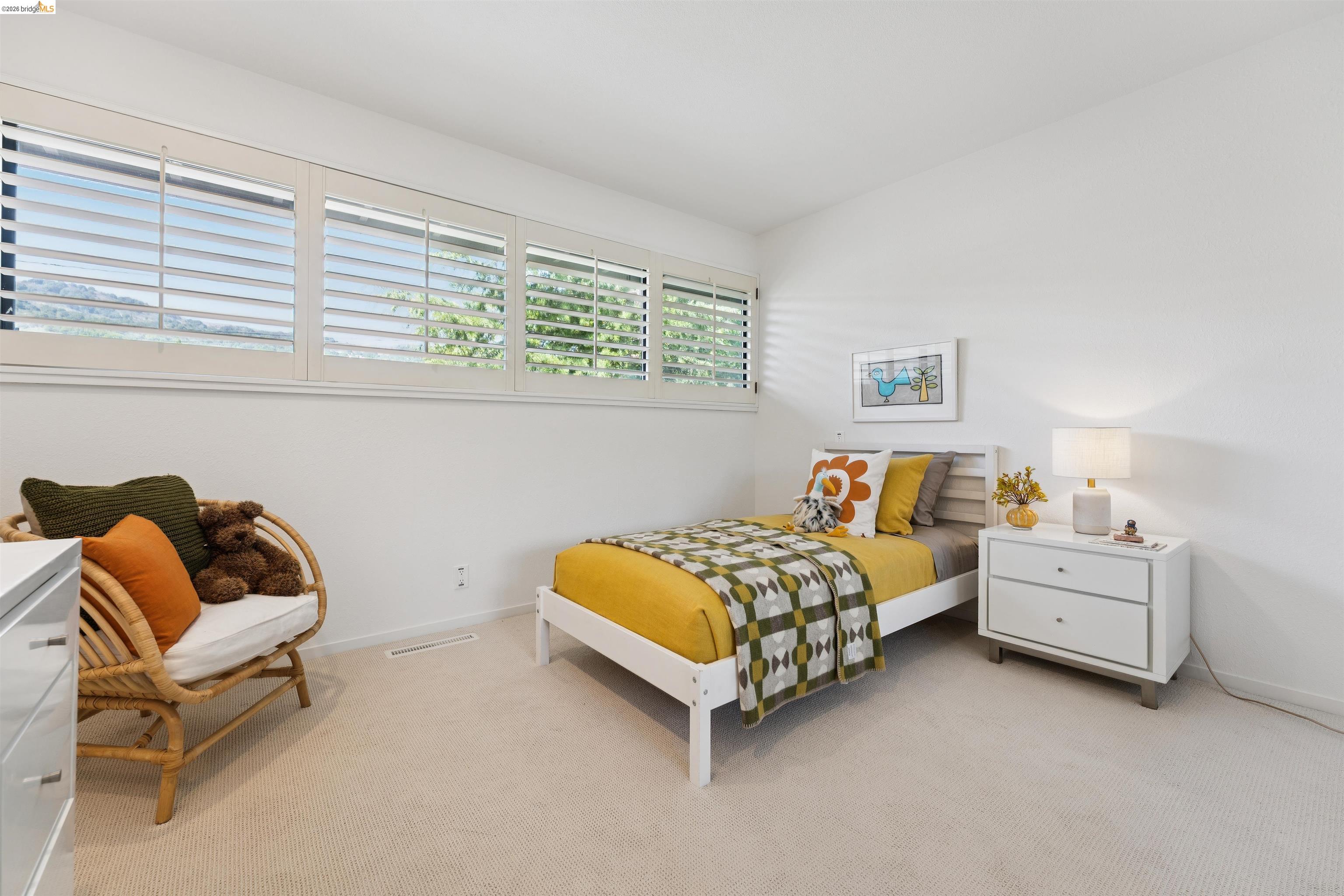 7 Jo Lin Court El Sobrante, CA 94803 - Photo 57 of 99 Bright bedroom featuring multiple windows with plantation shutters, neutral carpeting, and a built-in wall-mounted air vent