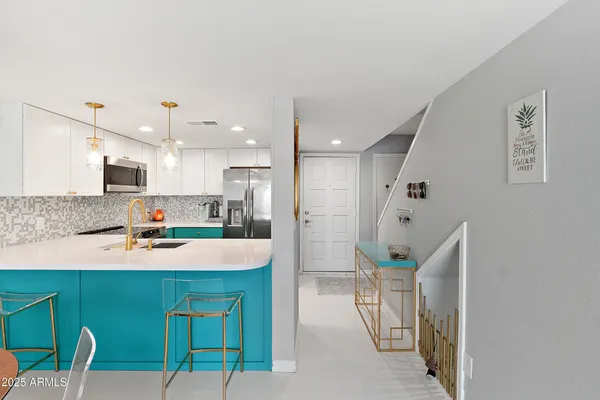 a large white kitchen with kitchen island a table and chairs