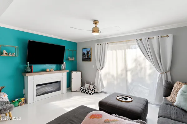 a living room with furniture a flat screen tv and a floor to ceiling window