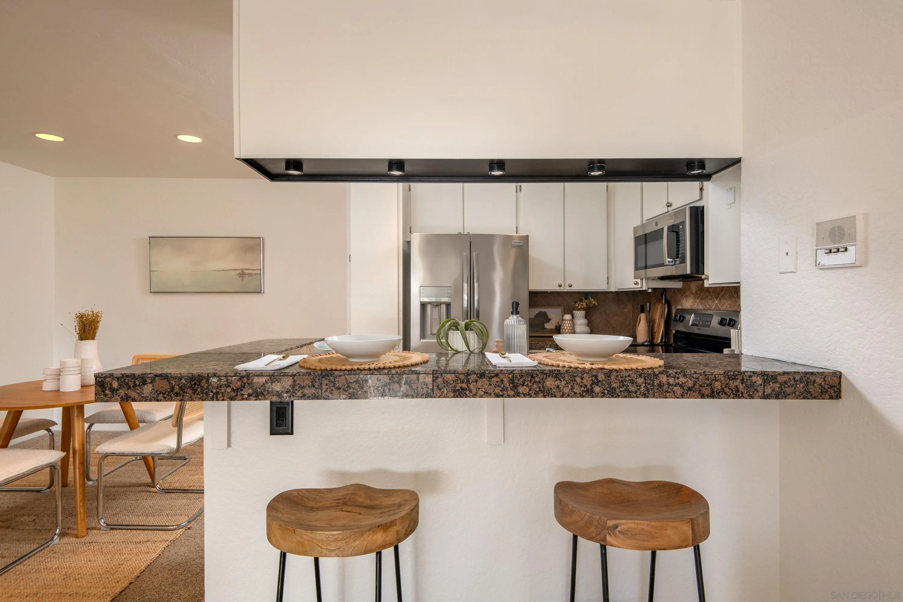 5705 Friars Road, Unit 54 San Diego, CA 92110 - Photo 12 of 30 a kitchen with stainless steel appliances granite countertop a sink and a refrigerator