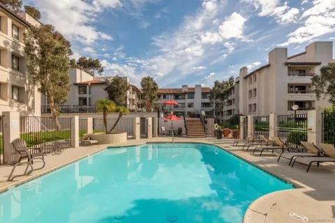 a view of a swimming pool with a patio and a yard