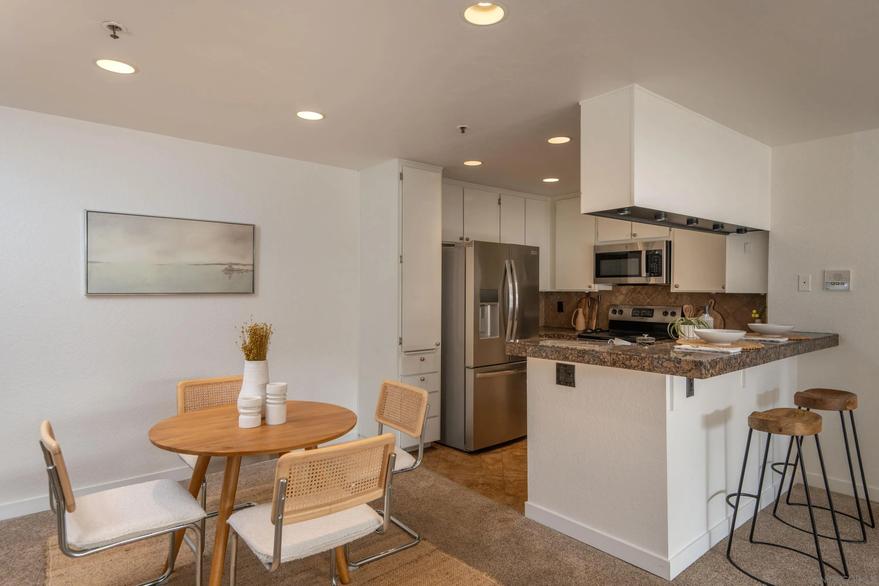 5705 Friars Road, Unit 54 San Diego, CA 92110 - Photo 10 of 30 a kitchen with stainless steel appliances kitchen island granite countertop a dining table and chairs