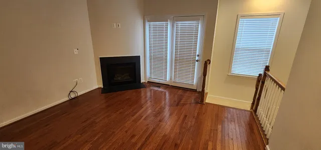 an empty room with wooden floor and fireplace