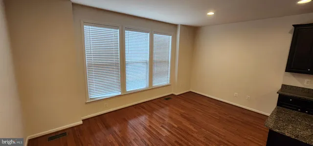 an empty room with wooden floor and a window