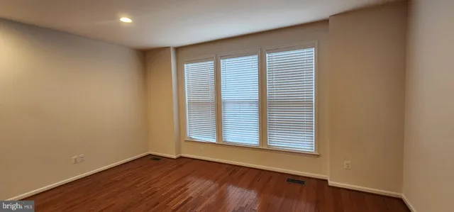 an empty room with wooden floor and a window