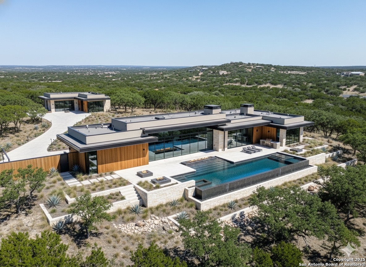 a view of a terrace with a table and chairs under an umbrella next to a yard
