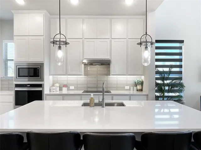 a close view of a sink a counter space a stove and cabinets