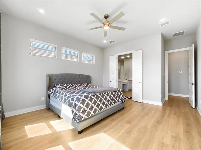a bedroom with a large bed and a chandelier
