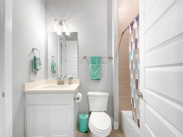 a bathroom with a sink a toilet a mirror and shower