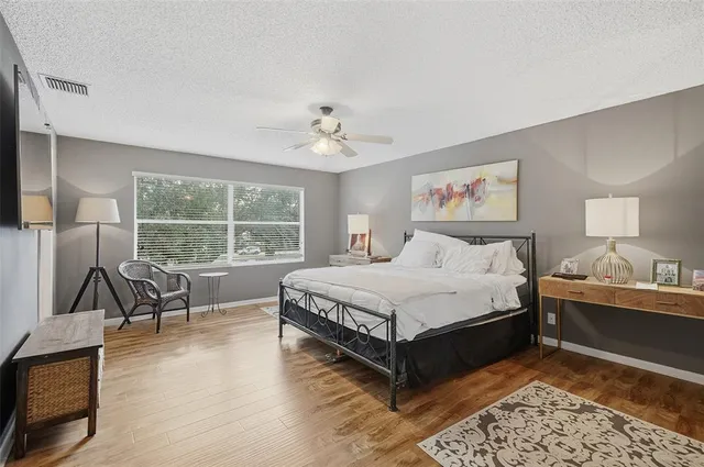 a spacious bedroom with a bed a table and chair