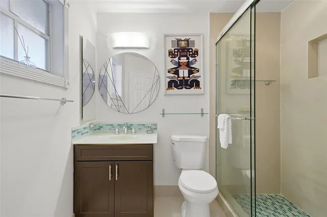 a bathroom with a toilet sink vanity and mirror