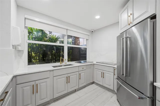 a kitchen with white cabinets and window