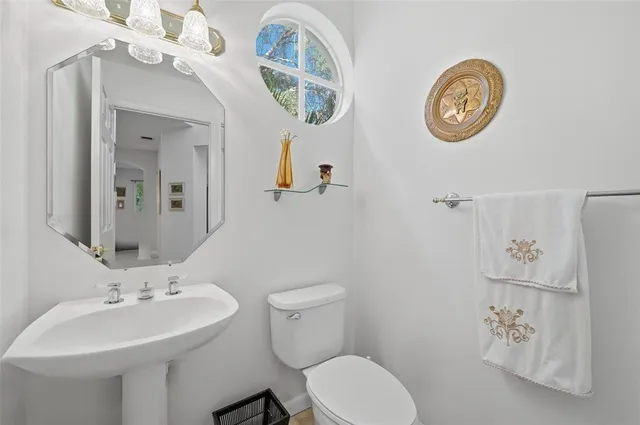 a bathroom with a toilet a sink and a mirror