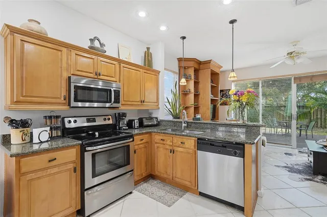 a kitchen with stainless steel appliances granite countertop a stove a sink and a microwave
