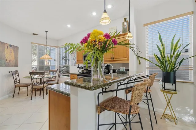 a dining room filled chandelier and kitchen view