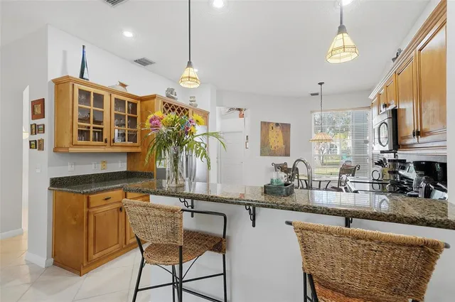a kitchen with stainless steel appliances granite countertop a sink a stove and a wooden floors
