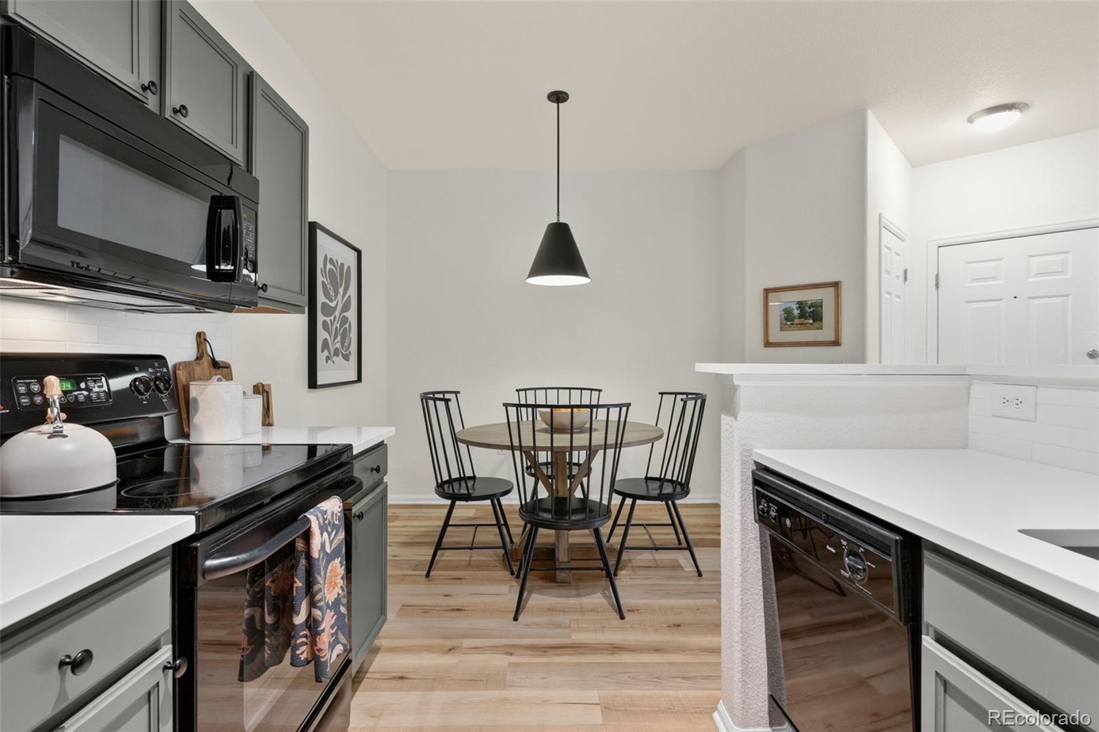 10733 Twenty Mile Road, Unit 208 Parker, CO 80134 - Photo 14 of 42 a kitchen with stainless steel appliances granite countertop a stove a sink a microwave a dining table and chairs