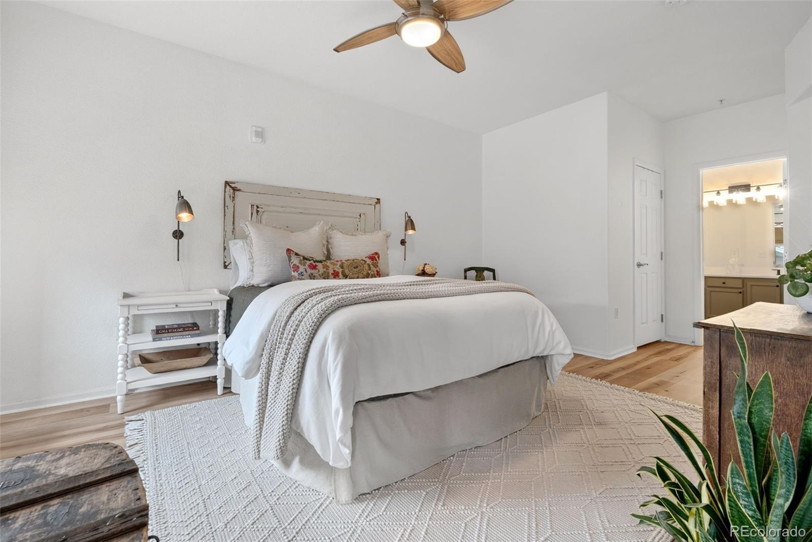 10733 Twenty Mile Road, Unit 208 Parker, CO 80134 - Photo 18 of 42 a bedroom with a bed and a chandelier