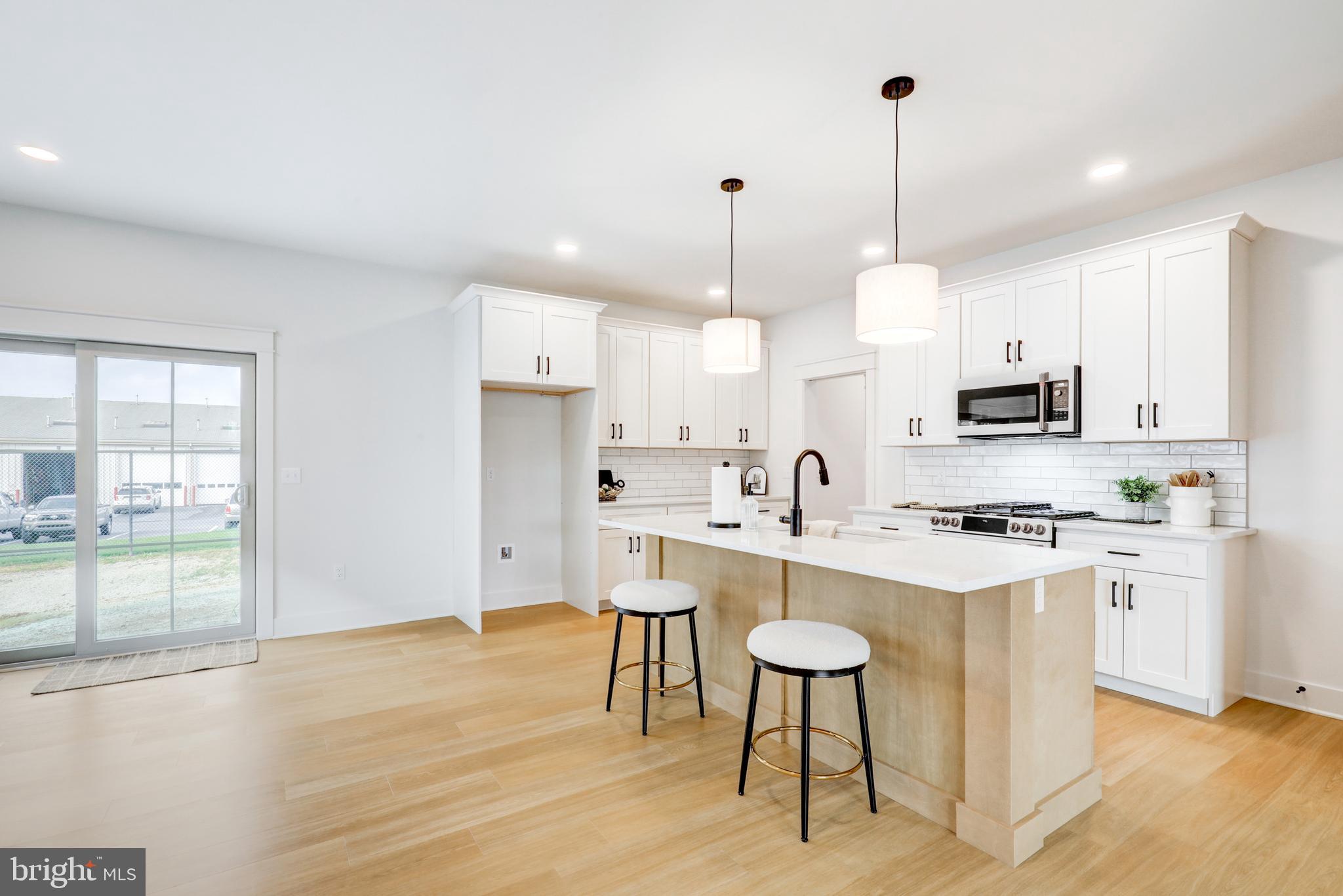 218 Parkside Place Lancaster, PA 17602 - Photo 10 of 48 a open kitchen with stainless steel appliances granite countertop a stove a refrigerator a kitchen island a sink dishwasher and white cabinets with wooden floor