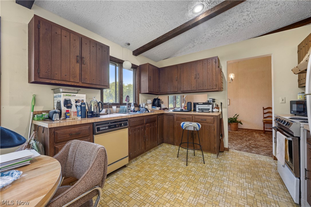 6451 Kungle Road Clinton, OH 44216 - Photo 19 of 34 Spacious kitchen featuring rich wood cabinetry, stainless steel appliances, and a geometric tile floor