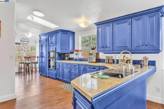 a kitchen with wooden cabinets and wooden floors