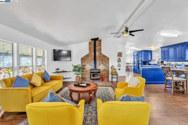 a living room with furniture kitchen view and a large window