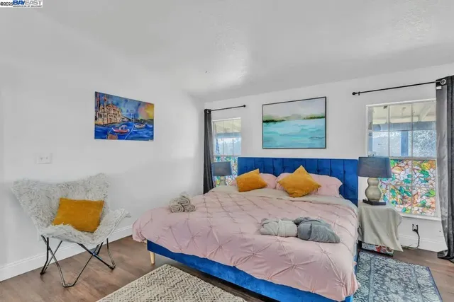 a bedroom with a bed and painting on the wall