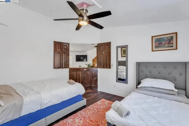 a bedroom with a large bed and wooden floor