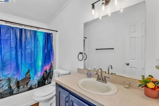 a bathroom with a sink vanity mirror and toilet