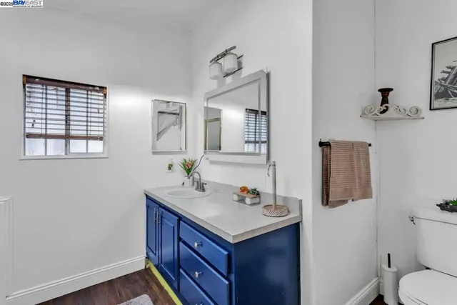 a bathroom with a granite countertop sink toilet and mirror
