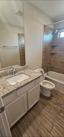 a bathroom with a sink a toilet a mirror and shower