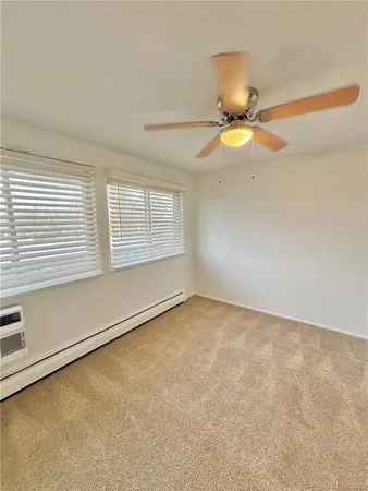 an empty room with a window and a ceiling fan