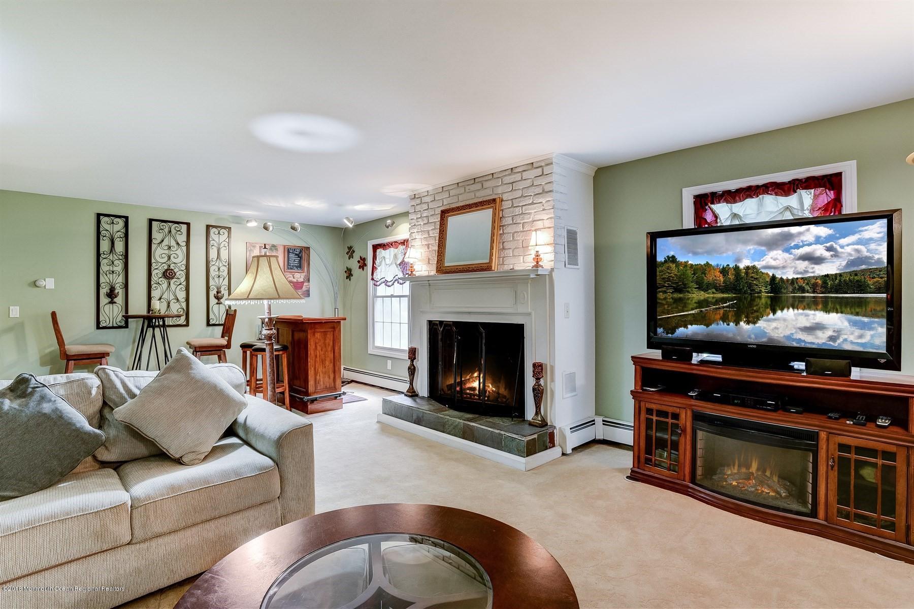 66 Thompson Bridge Road Jackson, NJ 08527 - Photo 9 of 34 a living room with furniture a flat screen tv and a fireplace