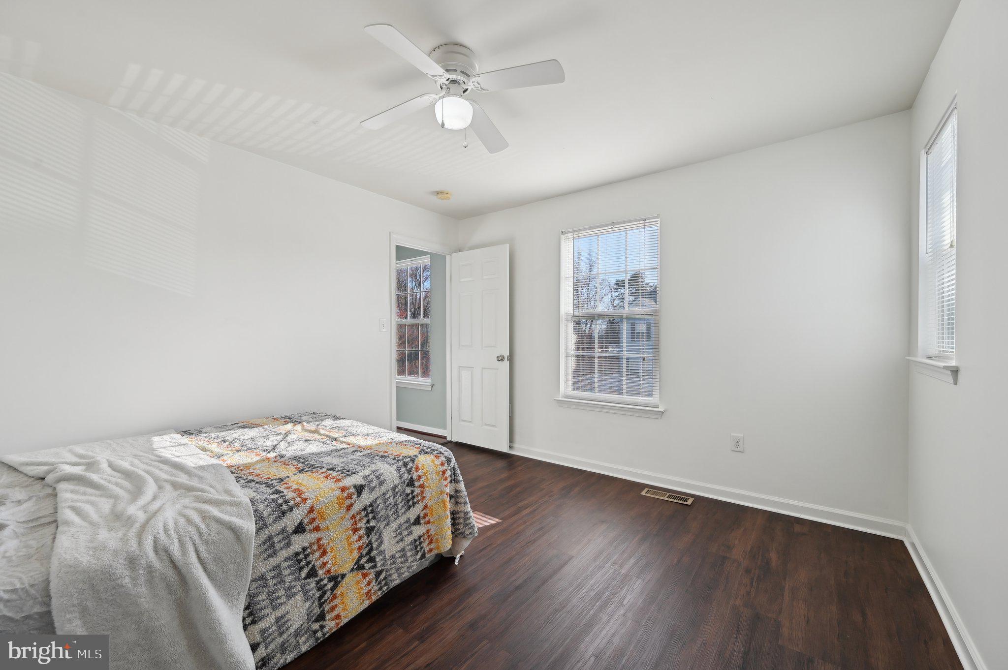 9552 Chaton Road Laurel, MD 20723 - Photo 30 of 53 a bedroom with a large bed window and a ceiling fan