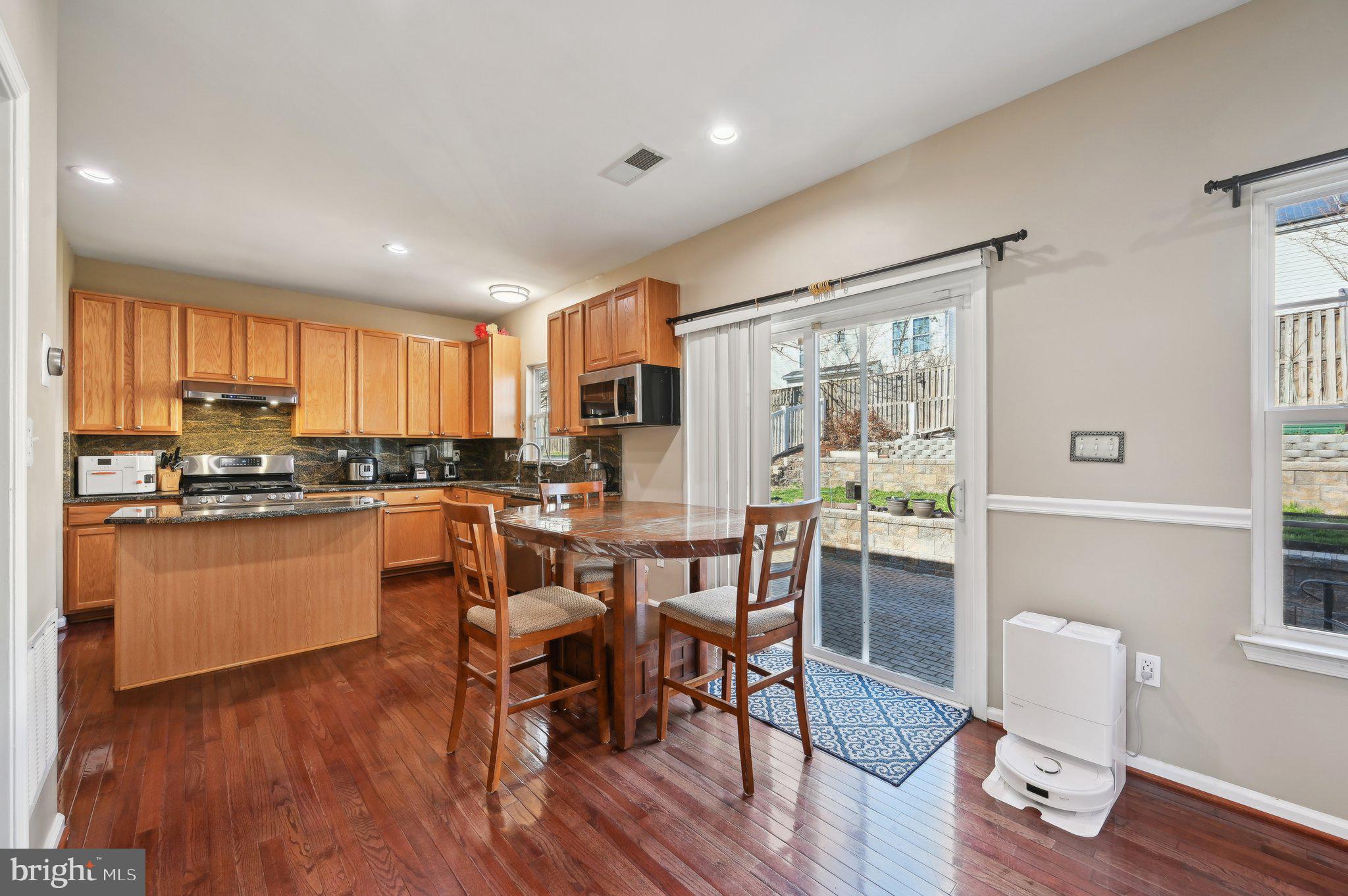 9552 Chaton Road Laurel, MD 20723 - Photo 8 of 53 a kitchen with stainless steel appliances granite countertop dining table chairs refrigerator and sink
