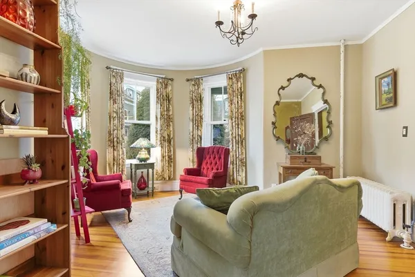 a bedroom with a bed wooden floor and windows