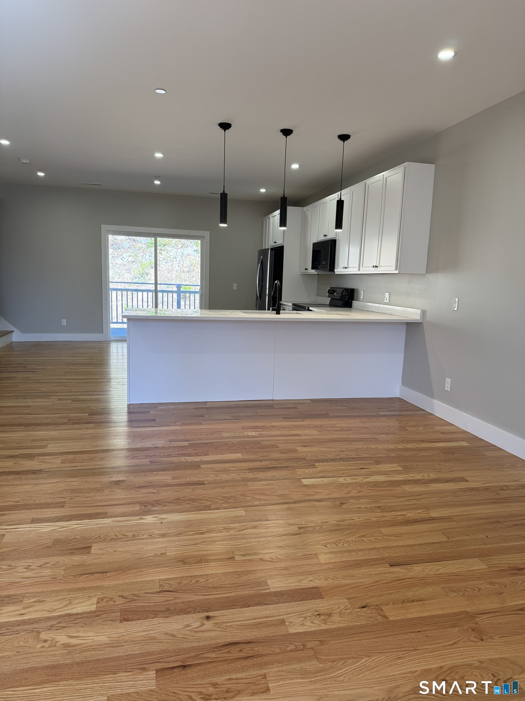 243 Echo Lake Road, Unit B10 Watertown, CT 06795 - Photo 7 of 10 a view of kitchen and empty room with wooden floor