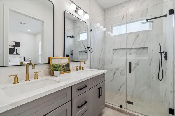 a bathroom with a granite countertop sink mirror and shower