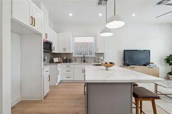 a kitchen with a sink cabinets and wooden floor