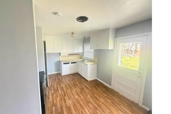 a kitchen with a refrigerator and white cabinets