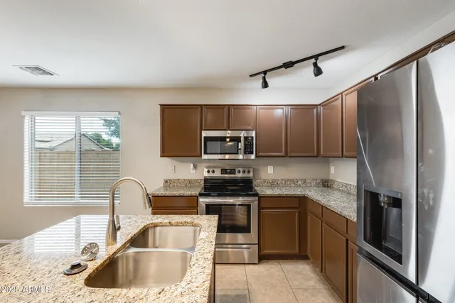 a kitchen with granite countertop a sink and a refrigerator